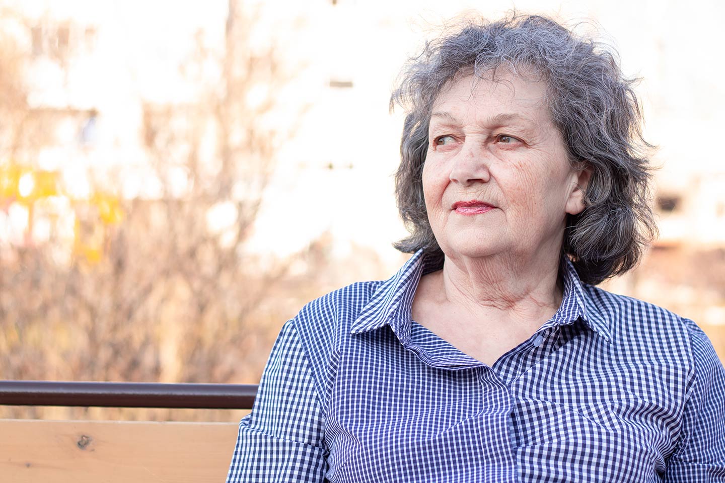 Photo of older woman in a check shirt looking sceptical