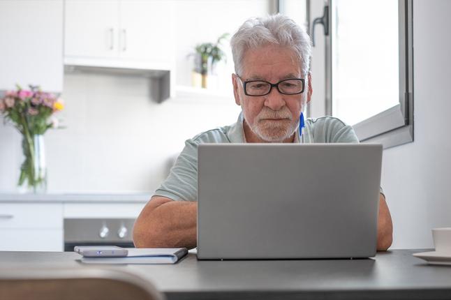 Photo of a man sitting in front of a laptop
