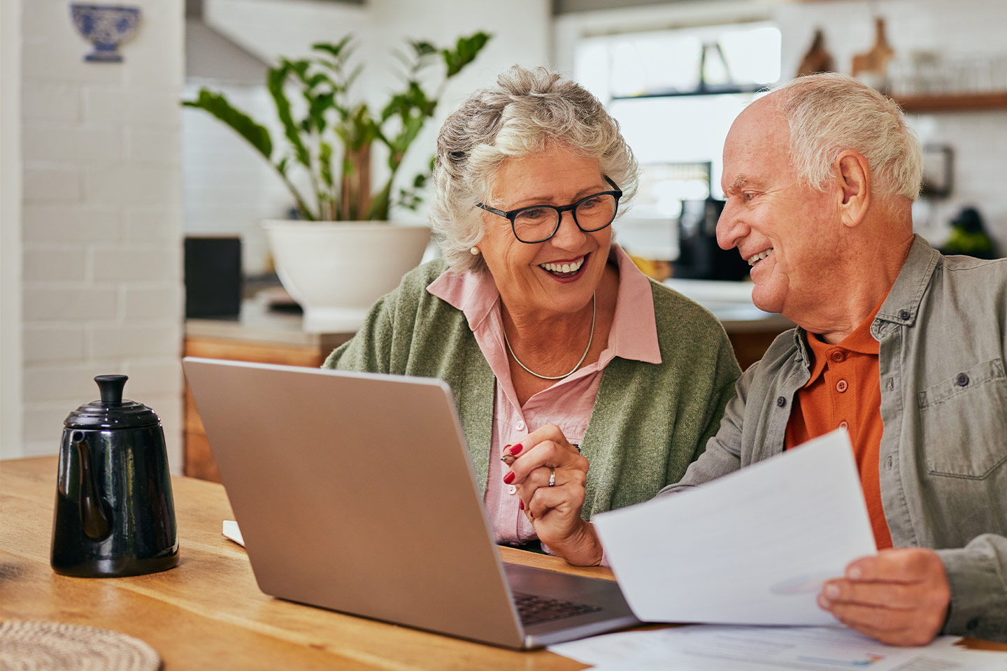 Photo of a smiling couple sitting at their laptop