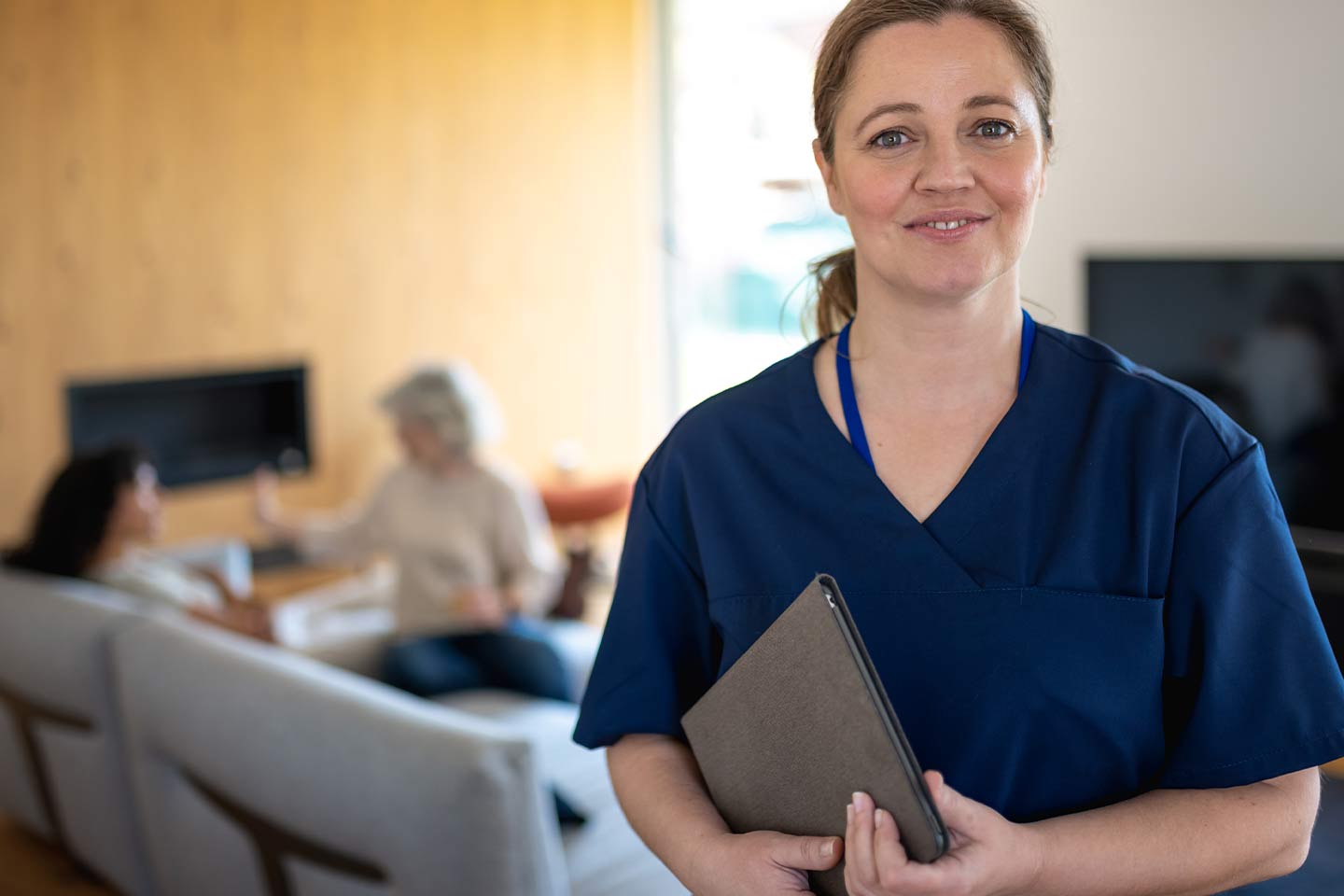 Photo of a smiling nurse wearing navy scrubs
