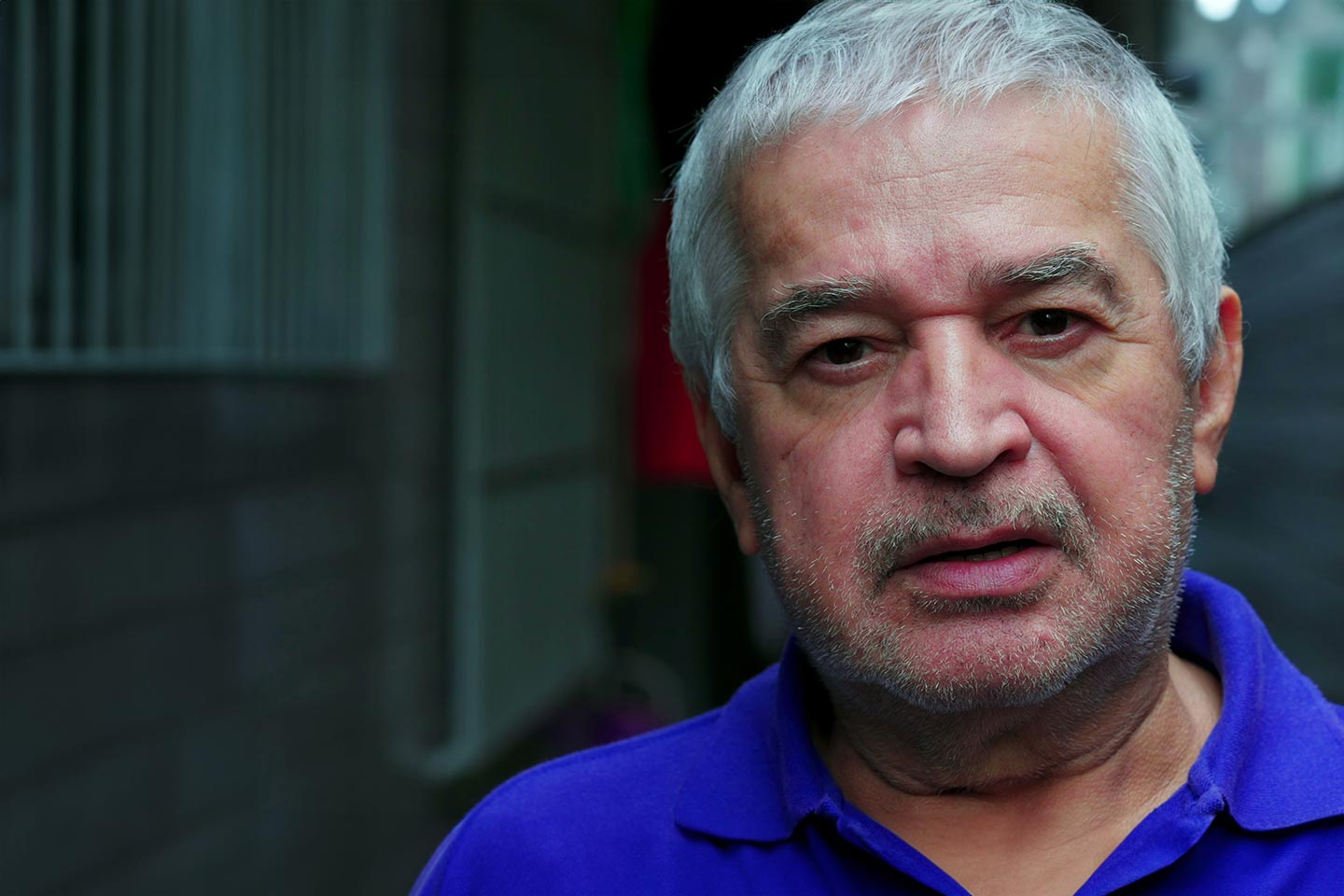 Photo of man in blue shirt looking at camera