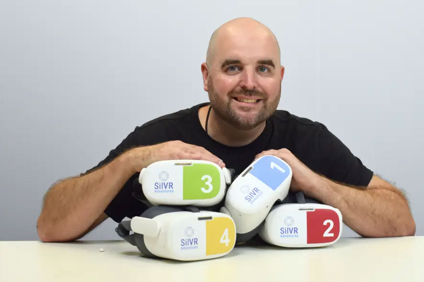 Photo of a smiling man with VR headsets