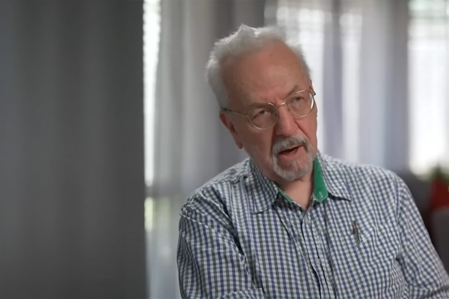 Photo of a man in a green gingham shirt and glasses