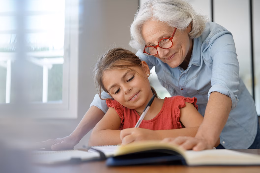 Photo of a grandmother helping a young girl with her homework