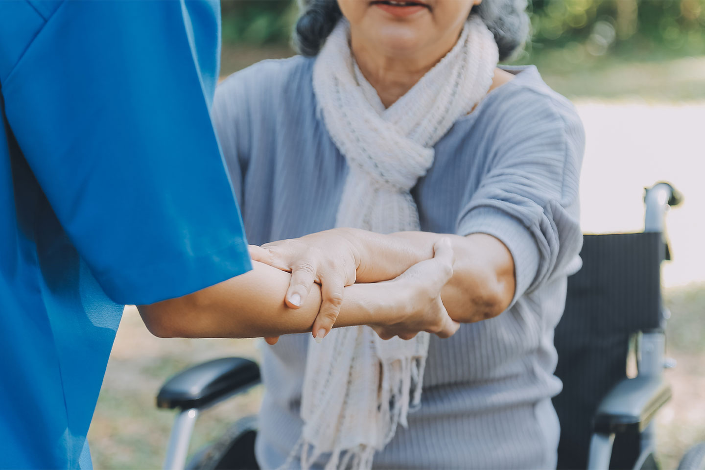Photo of a woman being helped out of her wheelchair