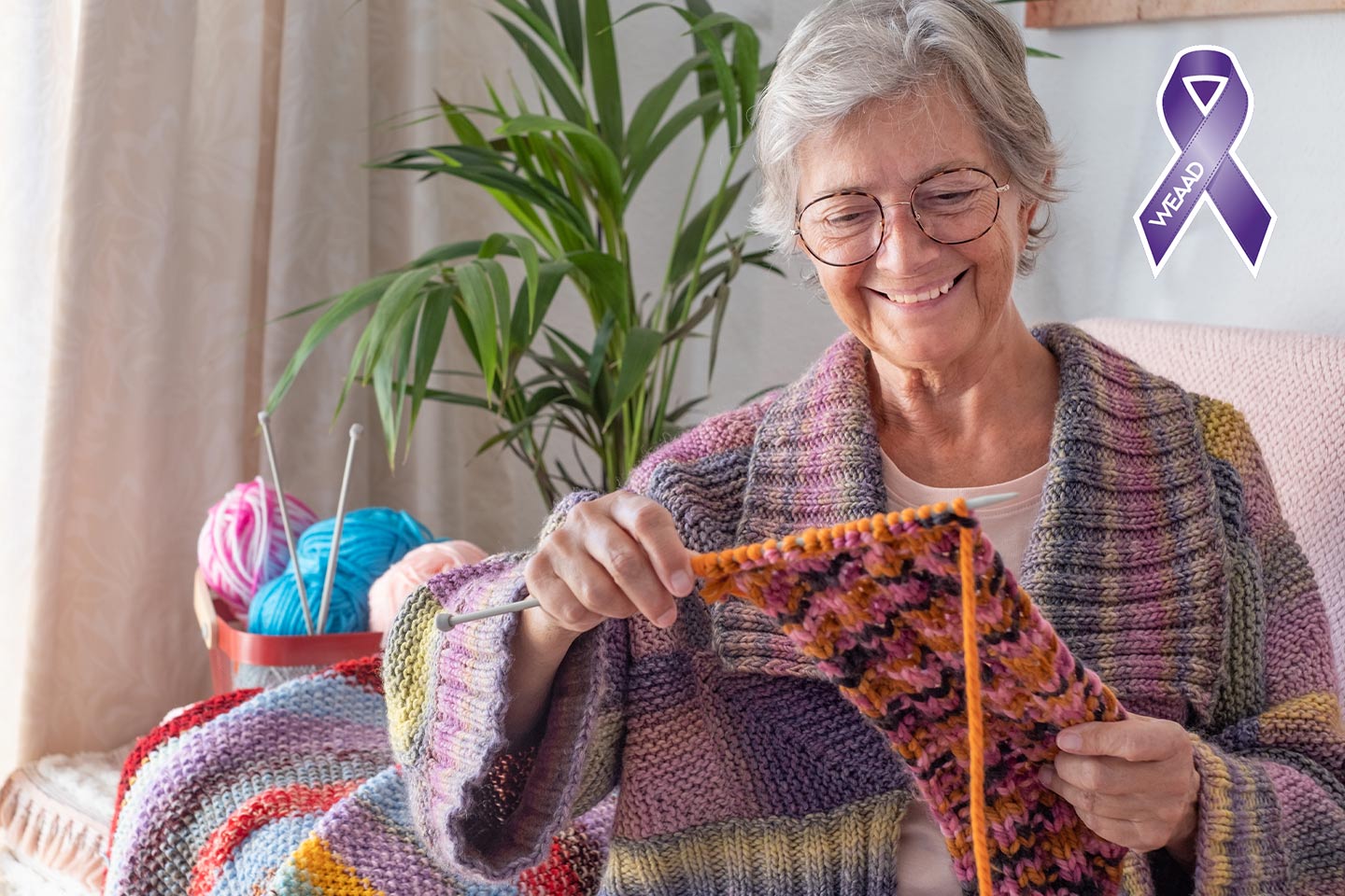 Photo of a woman smiling at her knitting