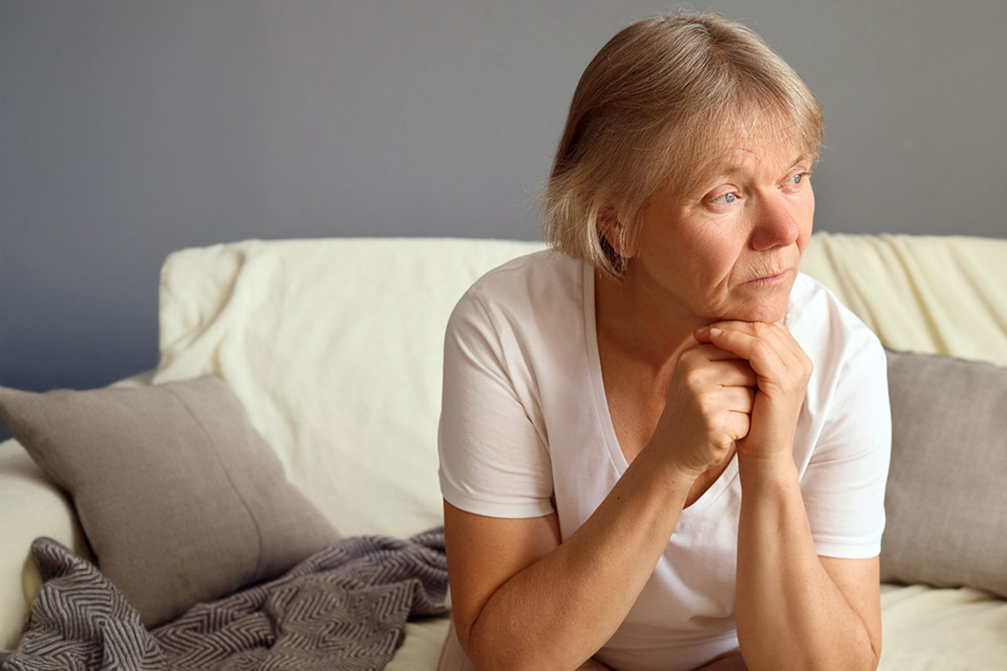 Photo of a woman in a white t-shirt looking pensive