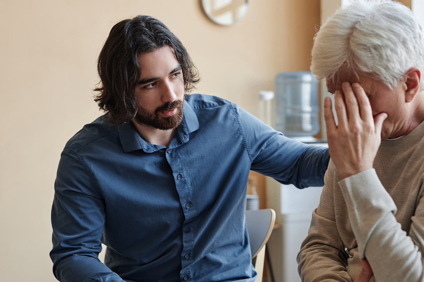 Photo of young man comforting an older person