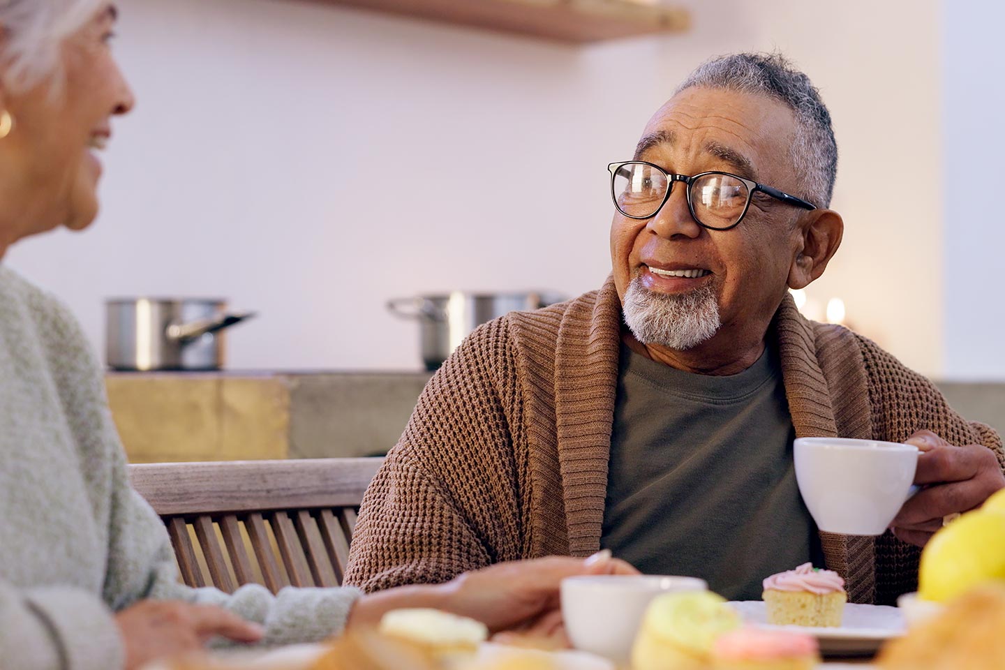 Image of an older man sharing a cup of tea with a friend