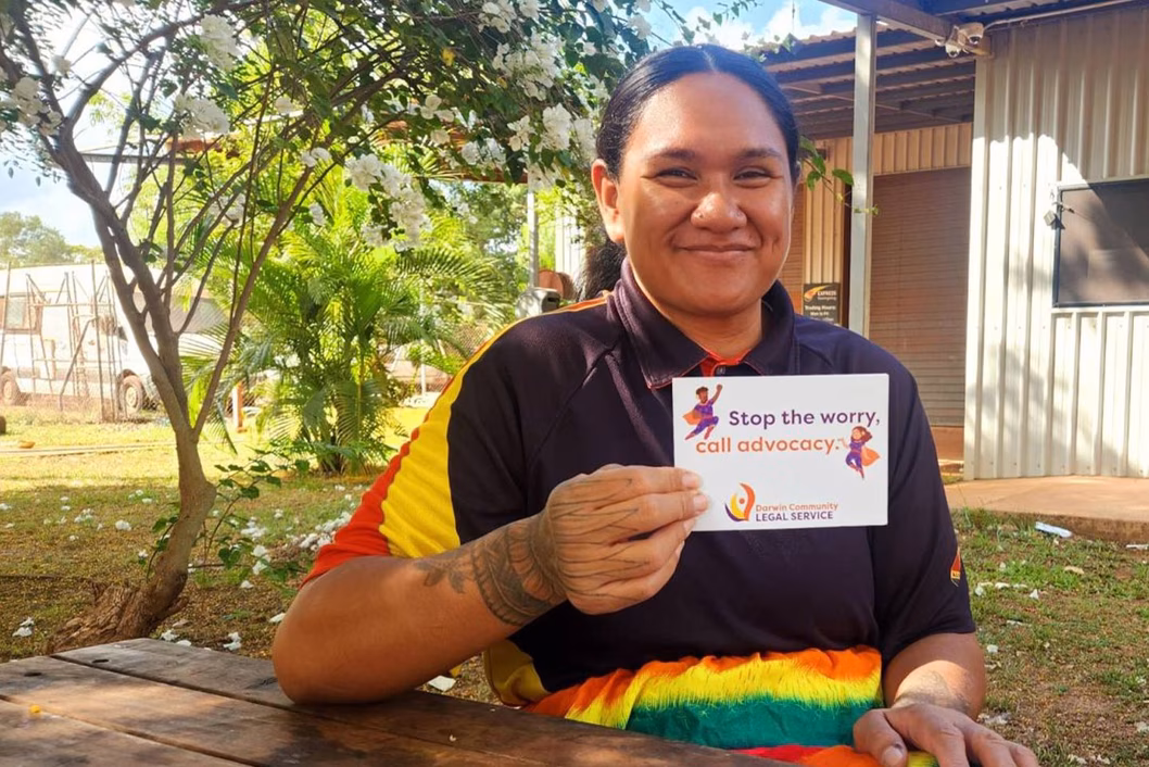 Photo of a woman sitting at a table under a tree