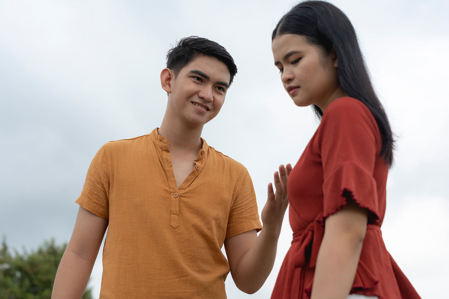 Photo of young couple against a cloudy sky
