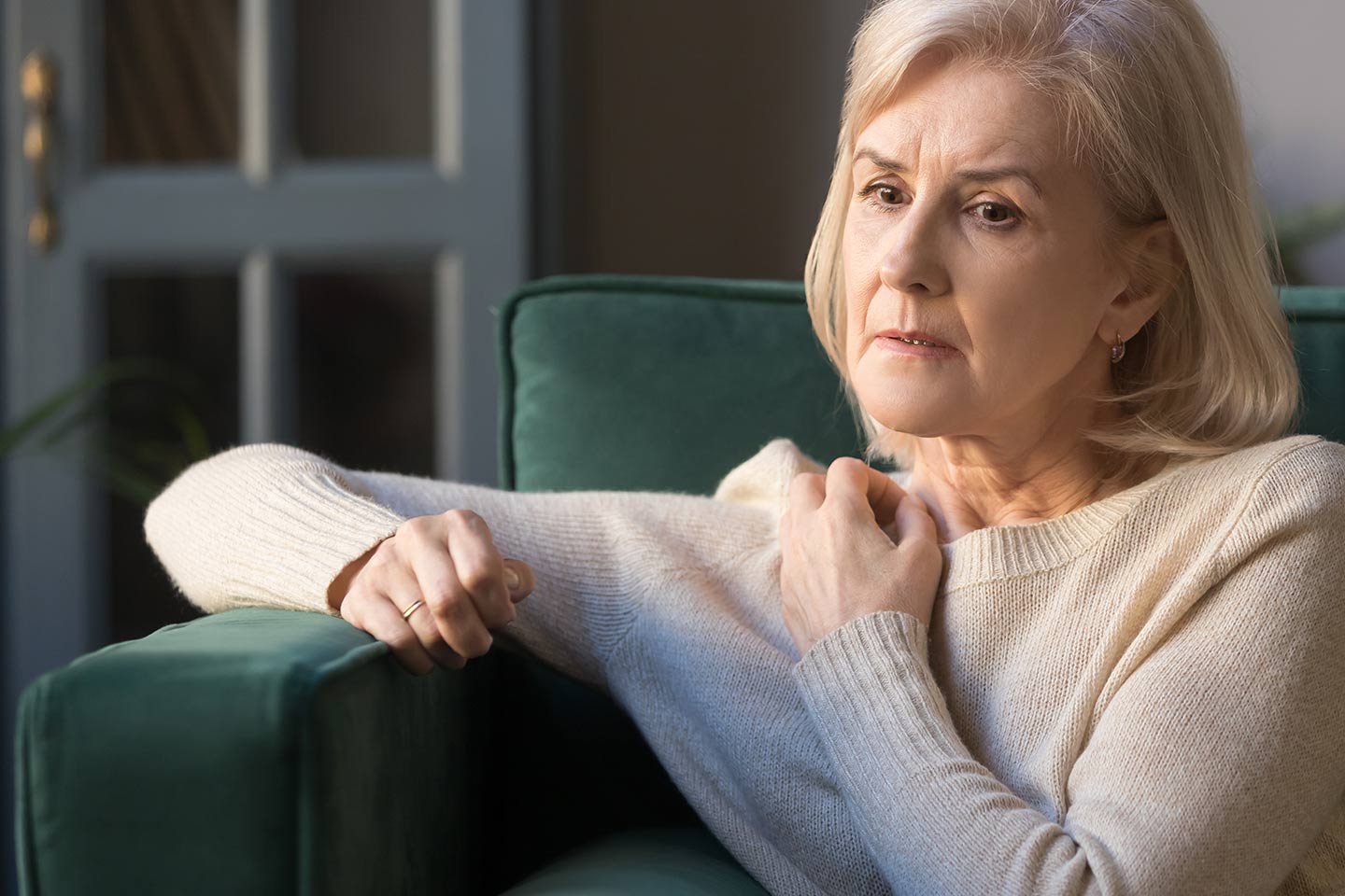 Photo of a woman with champagne-coloured bob in a green velvet chair