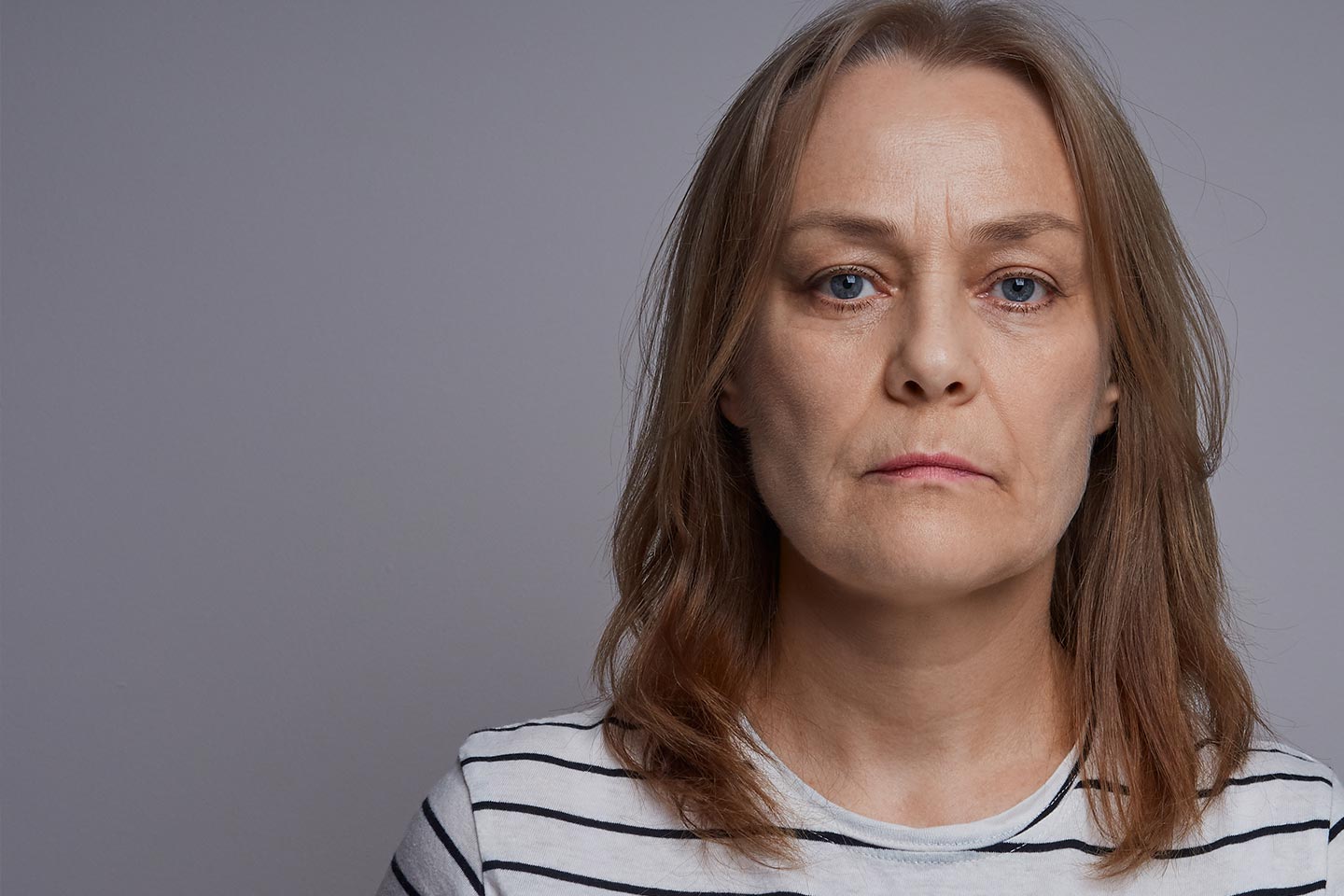 Photo of a woman in a striped top staring directly at the camera