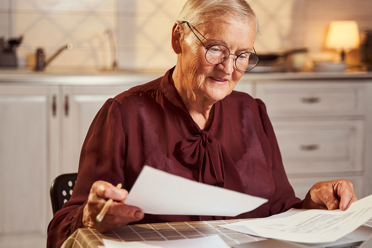 Image of an older woman wearing glasses looking at legal paperwork