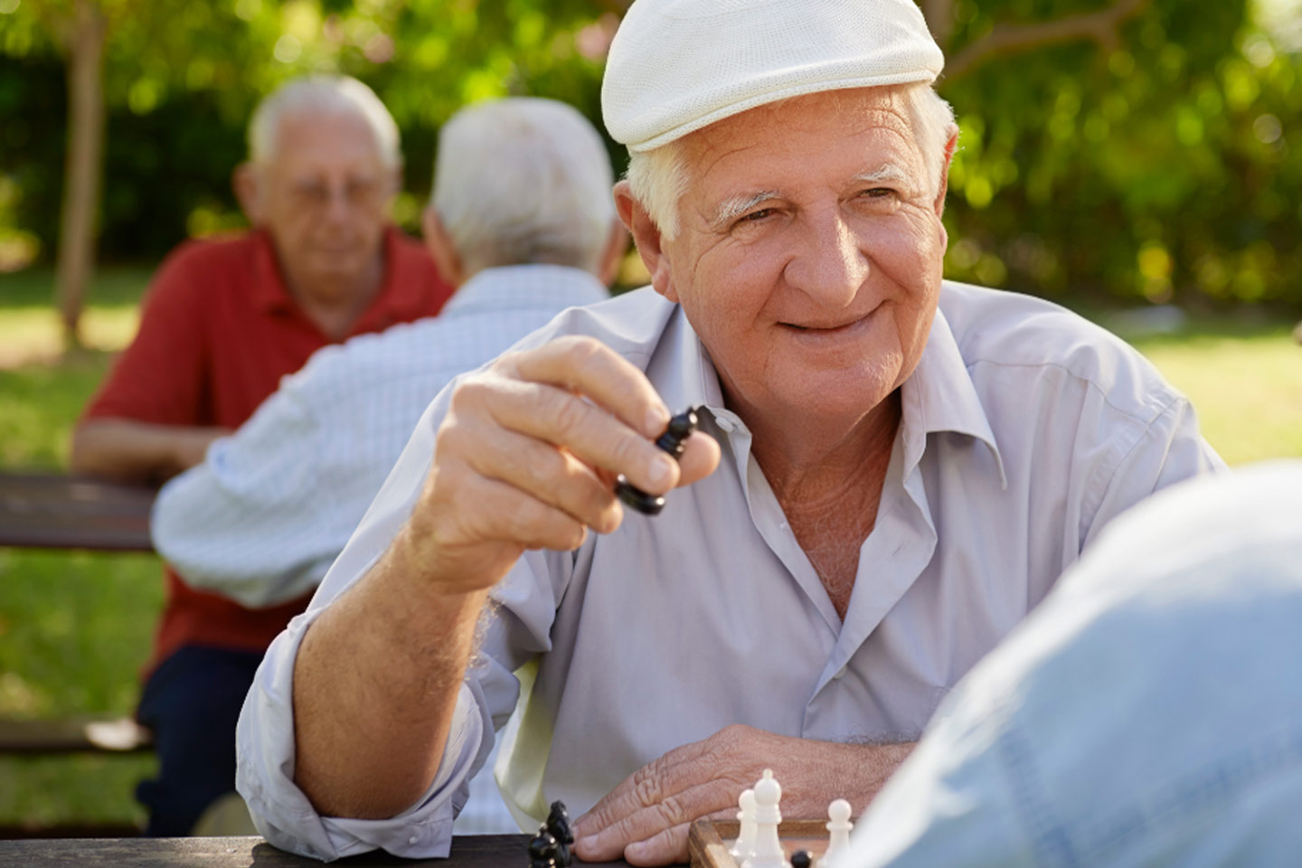 Photo of a man in a park playing chess