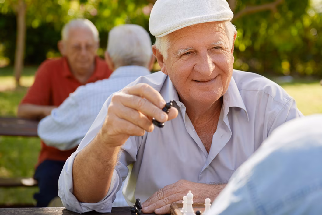 Photo of a man in a park playing chess