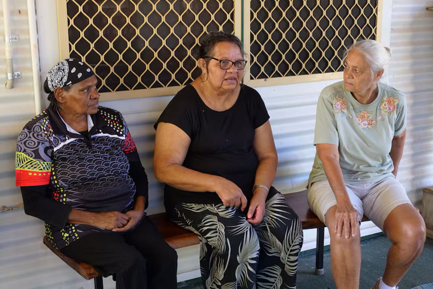 Photo of three women seated on a bench