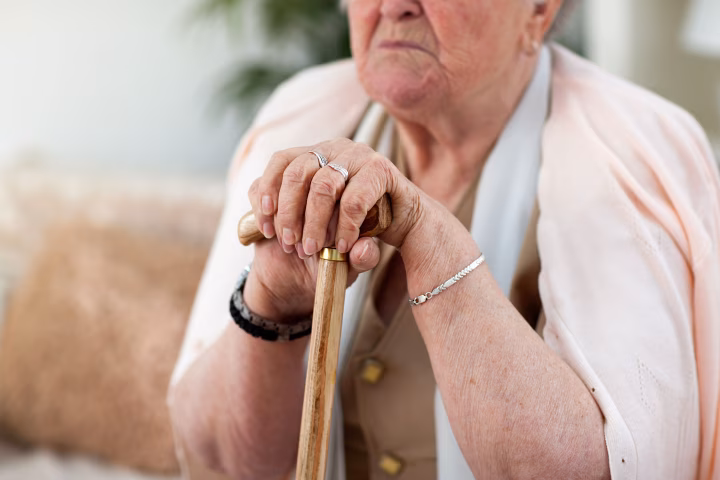 Senior woman's hands on cane 