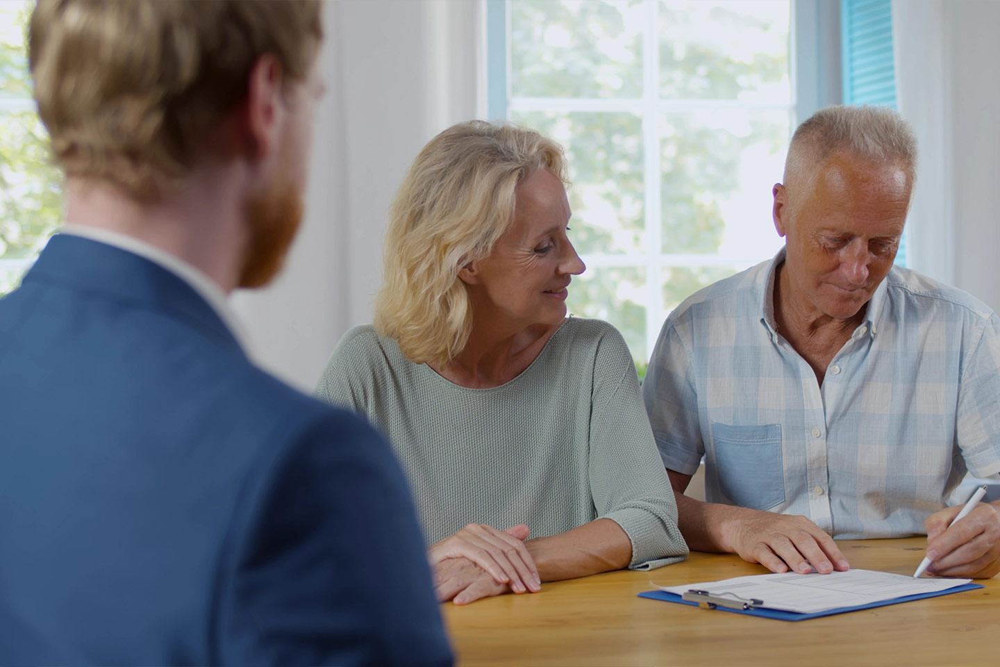 Photo of three people sitting at a table with paperwork