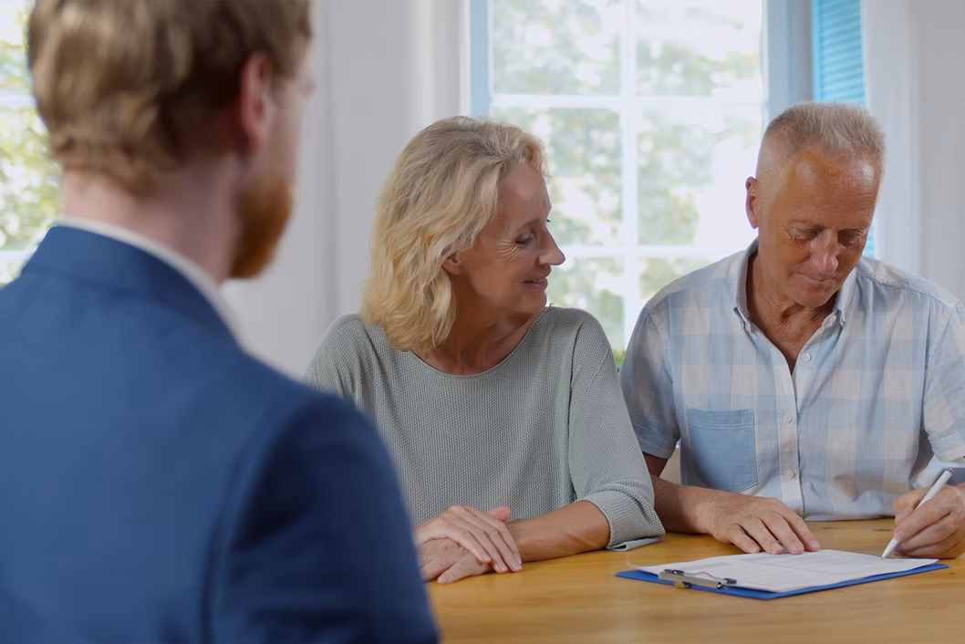 Photo of three people sitting at a table with paperwork