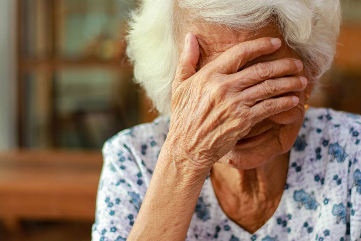 Photo of senior woman covering eyes with hand
