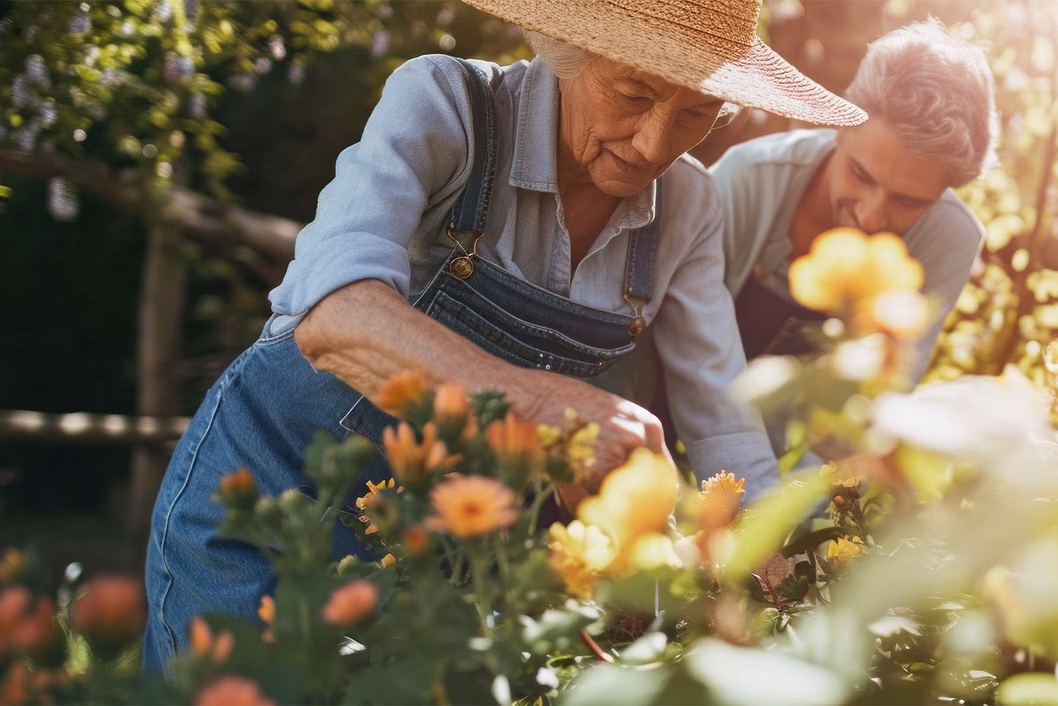 Photo of woman in a straw hat planting flowers in a garden