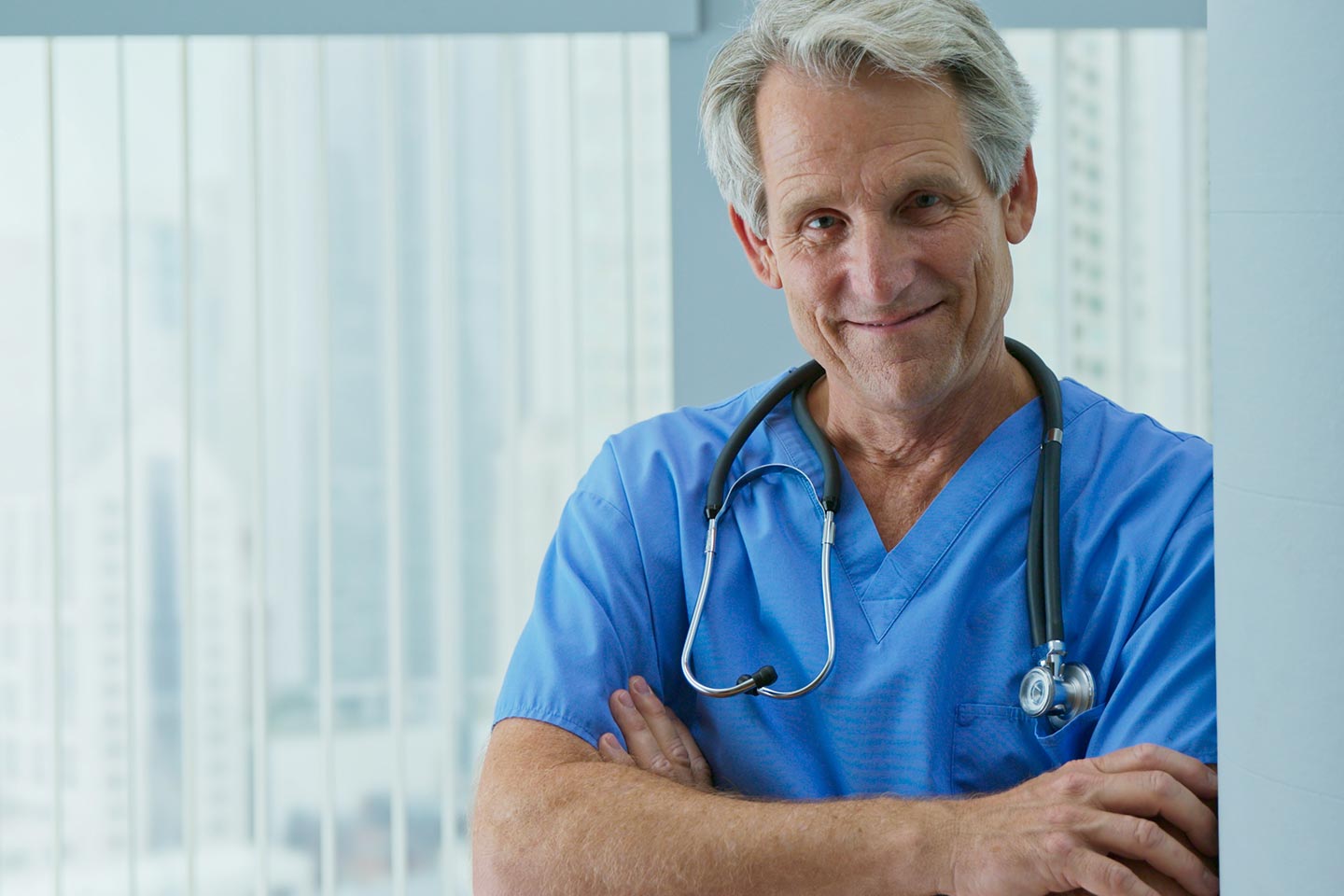 Photo of man in blue scrubs with stethoscope