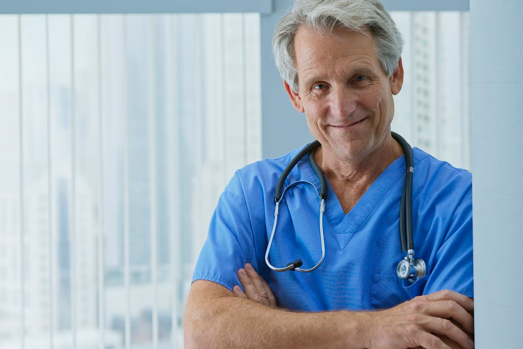 Photo of man in blue scrubs with stethoscope