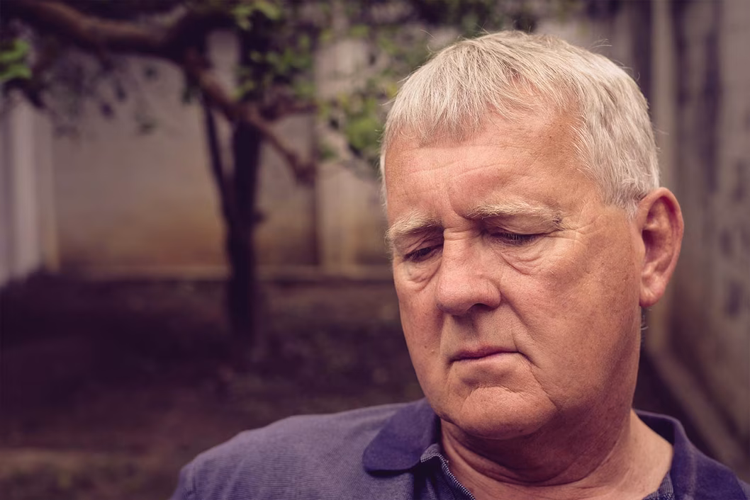 Photo of man in a courtyard wearing a purple polo shirt