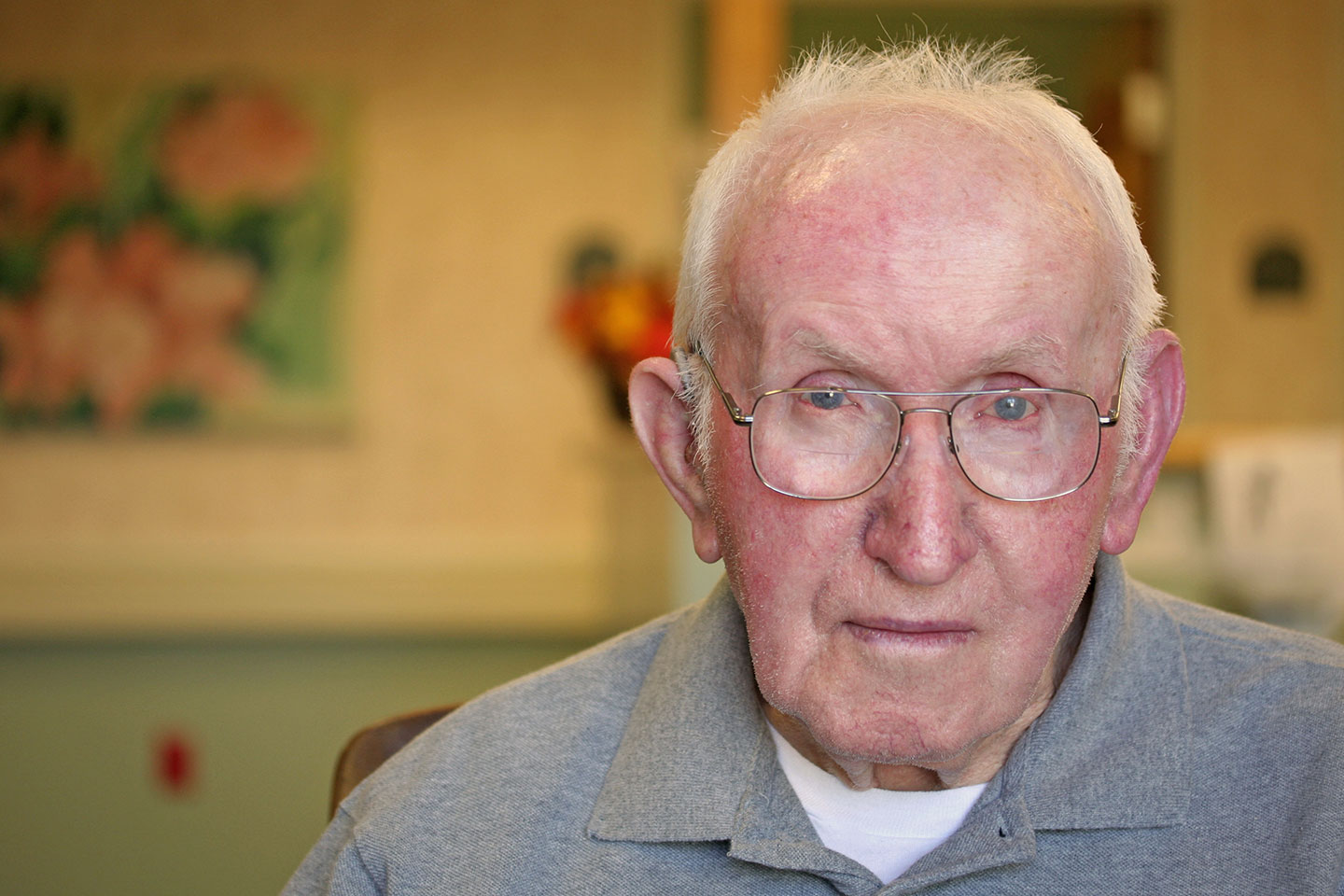 Photo of a man wearing wire rim glasses and a grey shirt