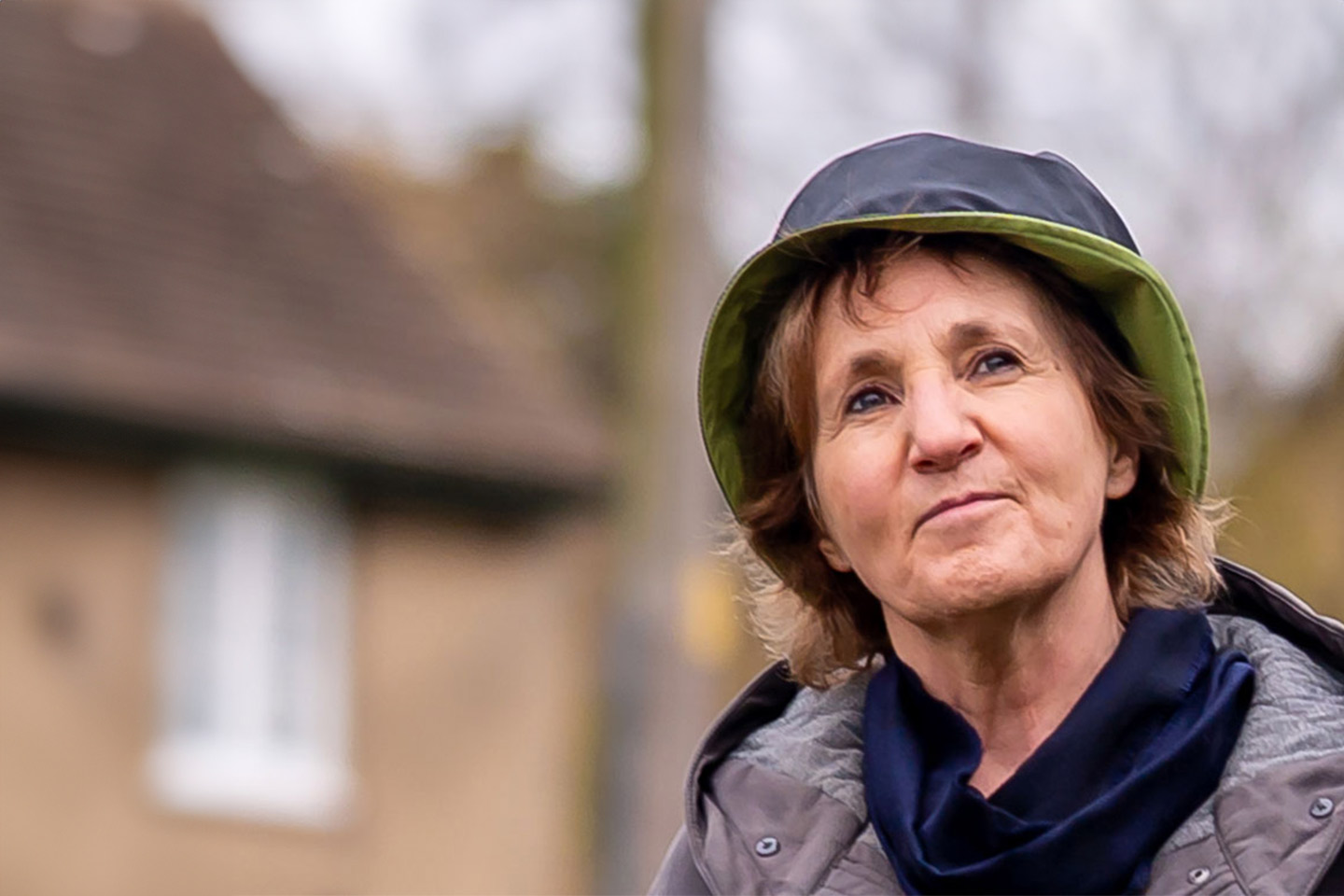 Photo of older woman in hat and raincoat