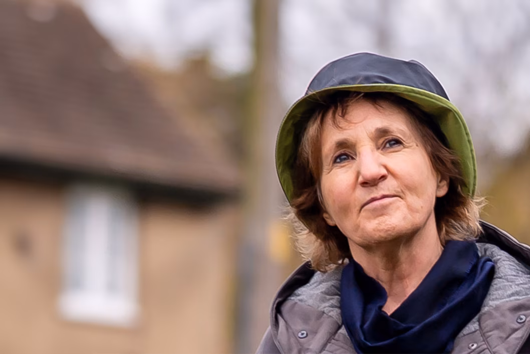 Photo of older woman in hat and raincoat