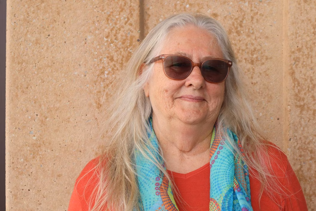 Photo of woman in a red top and blue scarf wearing sun glasses