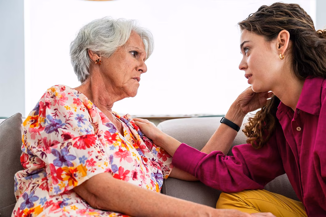 Photo of two women sitting together on a couch