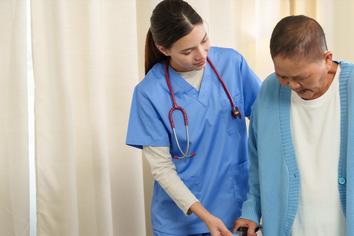 Photo of a health worker helping a person with a blue cardigan