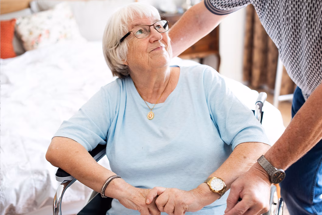 Photo of a woman in a baby blue t-shirt sitting in a wheelchair