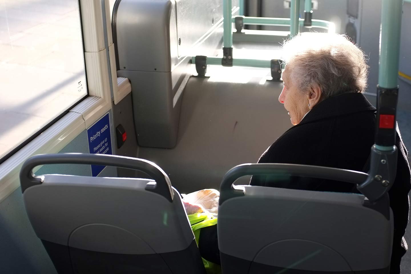 Photo of woman in a dark coat sitting in a bus