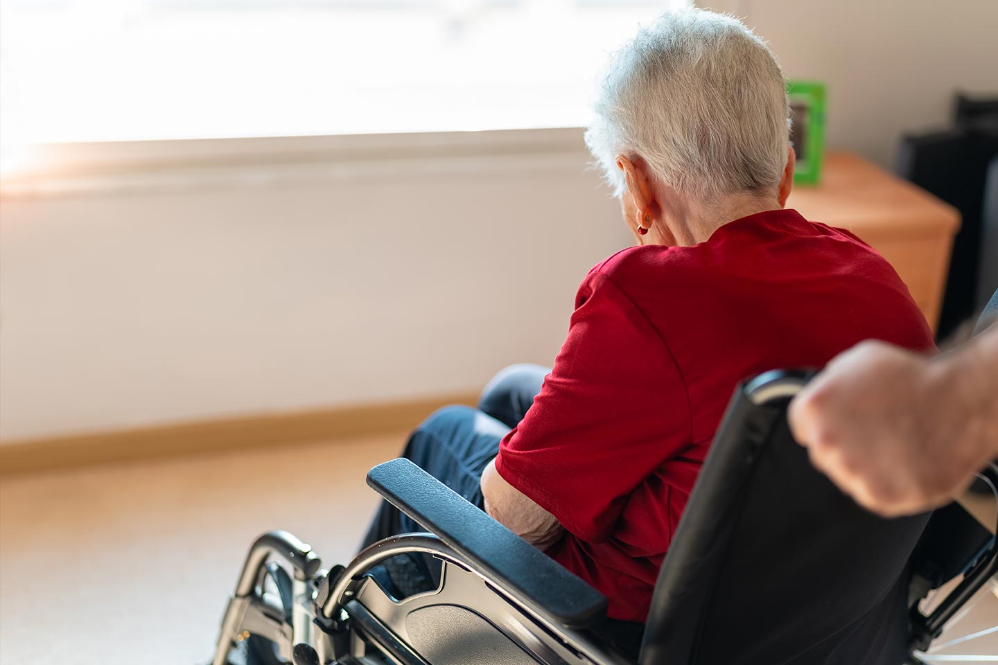 Photo of a woman wearing a red blouse in a wheelchair