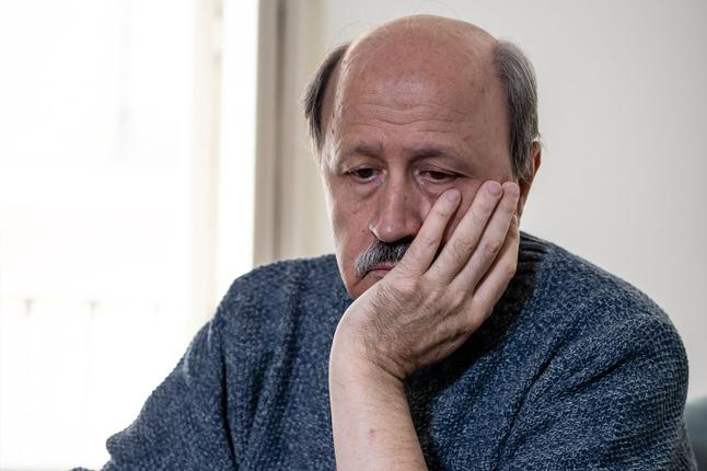 Photo of a balding man with his chin in his palm