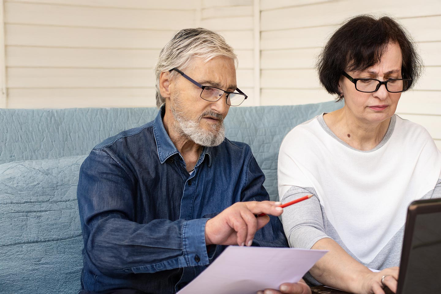 Image of an older husband and wife reviewing financial documents