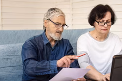 Image of an older husband and wife reviewing financial documents