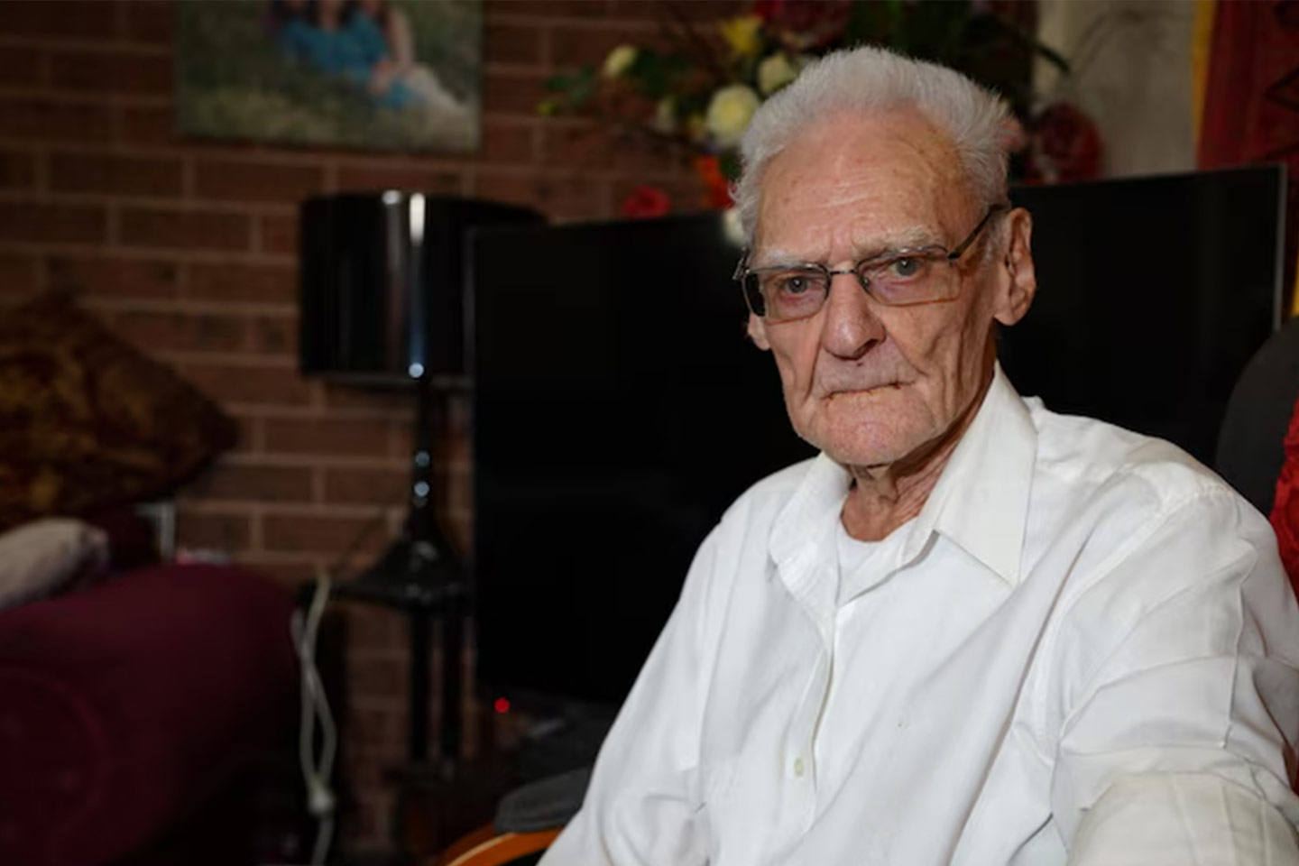 Photo of a man wearing glasses and a white shirt
