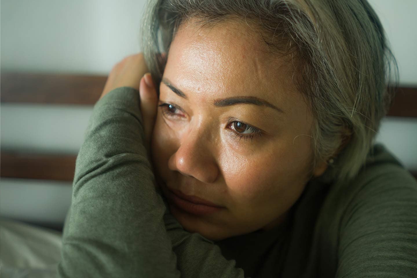 Photo of a sad woman in a sage green top
