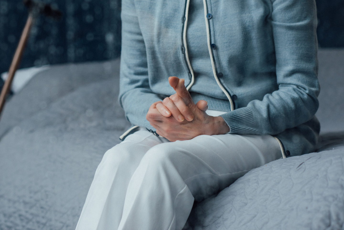 Close up of senior woman sitting on a bed