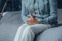 Close up of senior woman sitting on a bed