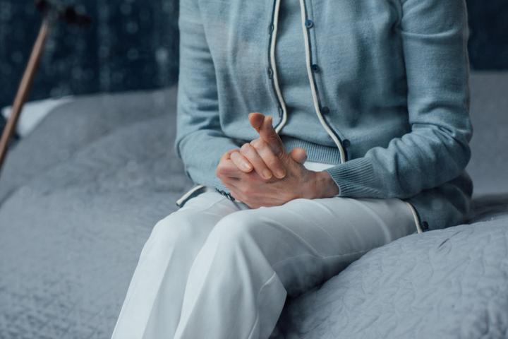 Close up of senior woman sitting on a bed