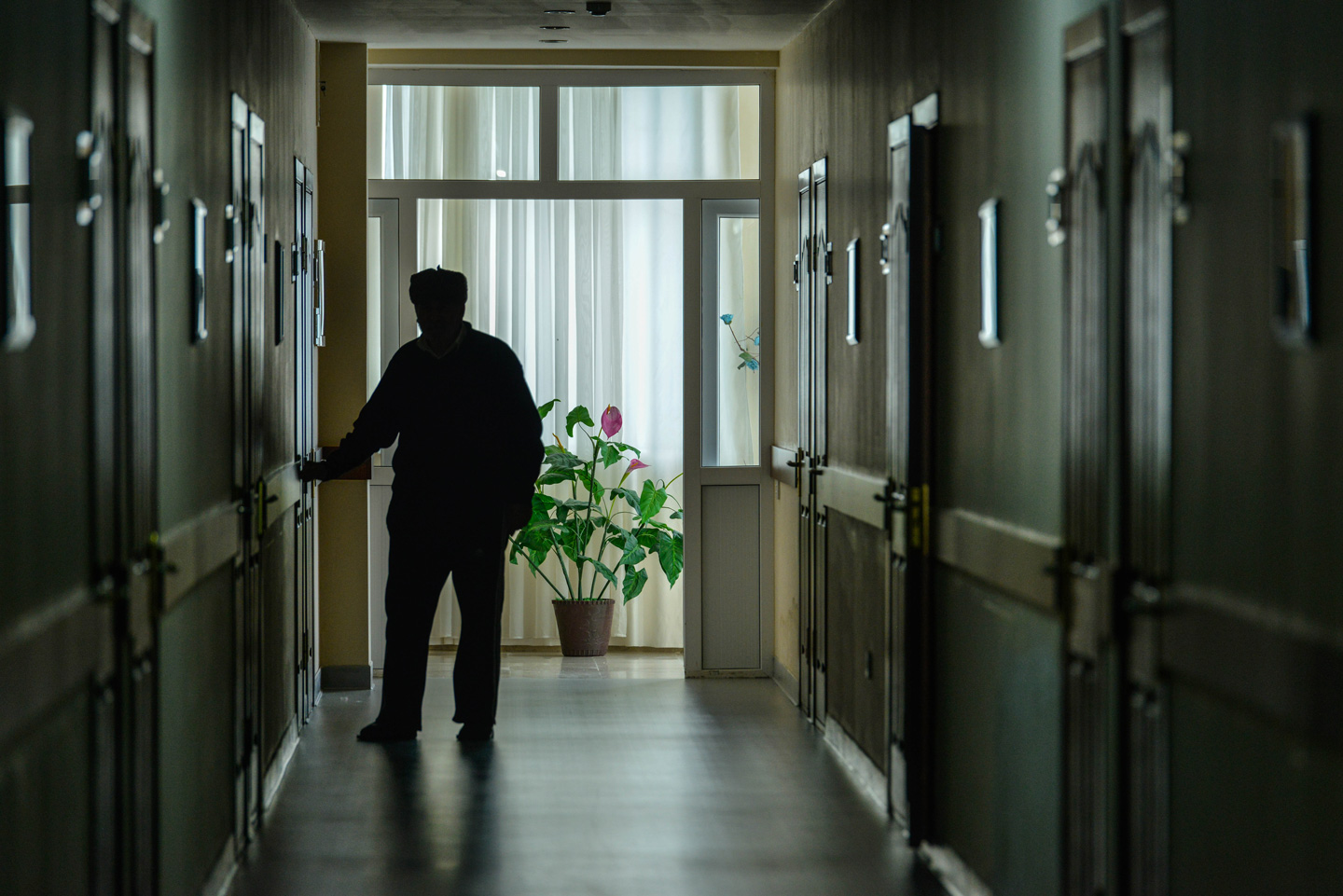 Senior man walking down the hall of an aged care home