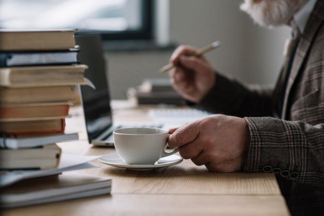Senior man working and drinking coffee