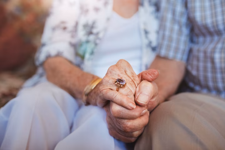 Close up of seniors holding hands. 