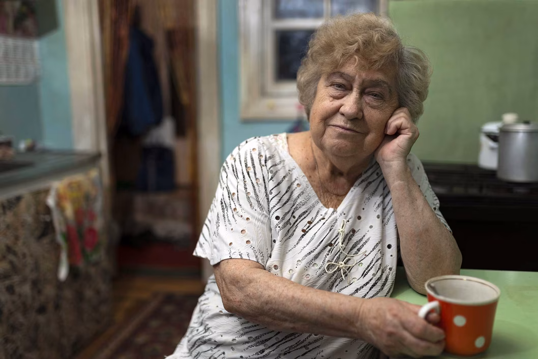 Compass image of an older women drinking coffee